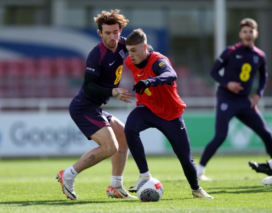 Cole Palmer and Ben Chilwell of England battle for possession during a training session at St Georges Park on March 22, 2024 in Burton-upon-Trent, England.