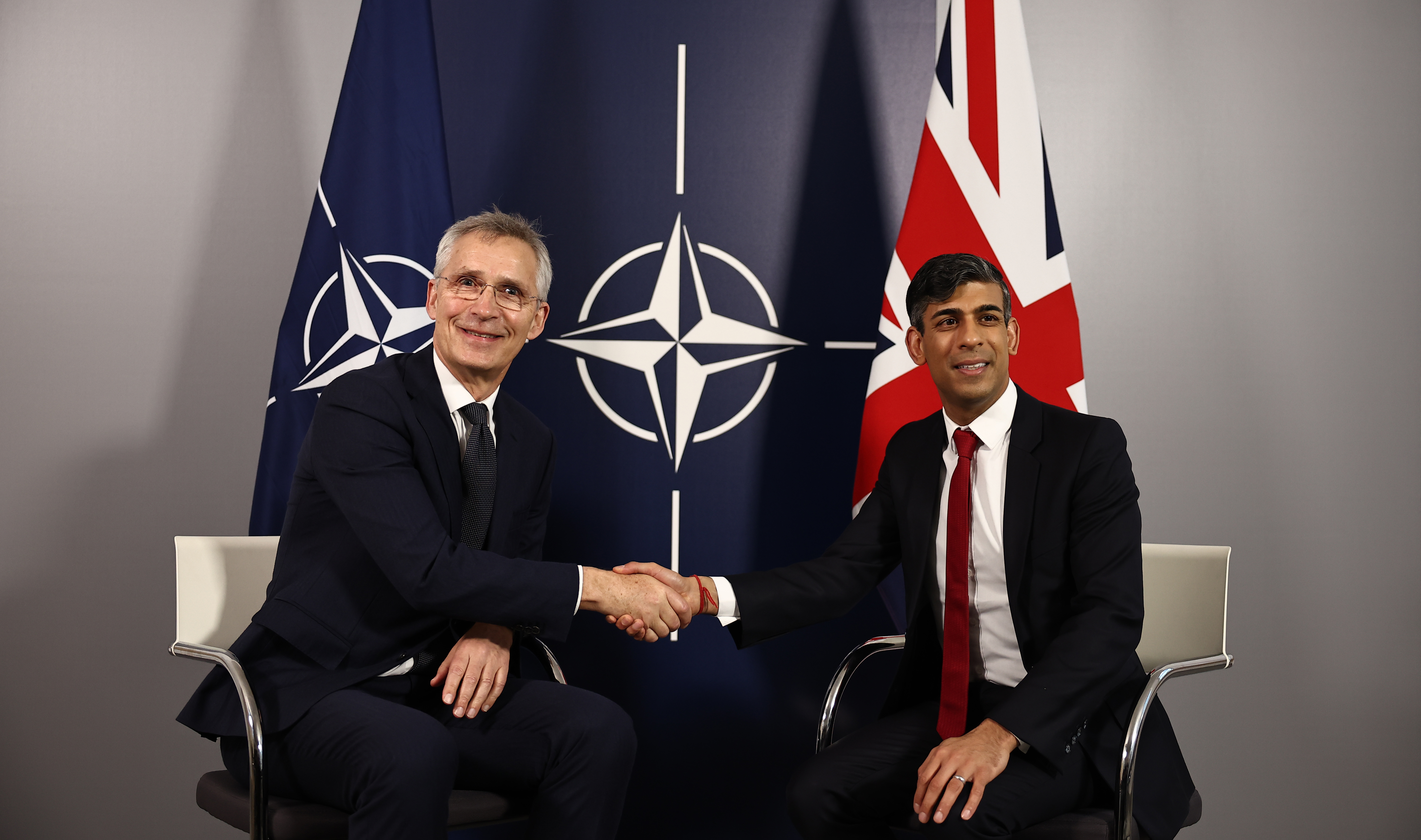 NATO Secretary General Jens Stoltenberg and Prime Minister Rishi Sunak shake hands prior to talks at the Warsaw Armoured Brigade