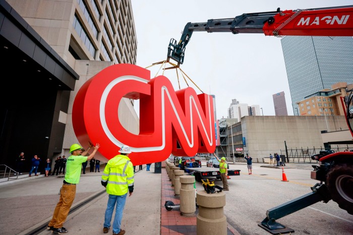 A crane lifts the CNN sign onto a flatbed truck 