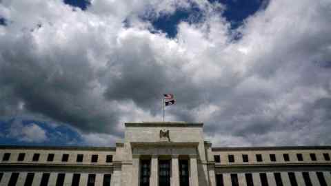 Flags fly over the Federal Reserve building on a windy day in Washington