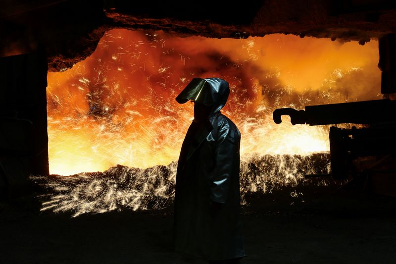 © Reuters. FILE PHOTO: A steel worker in heat protection gear is silhouetted against the sparkling fire of Europe’s largest  furnace with its daily raw iron production of 12,000 tons, at the steel plant of ThyssenKrupp in Duisburg, Germany, November 16, 2023.  REUTERS/Wolfgang Rattay/File Photo