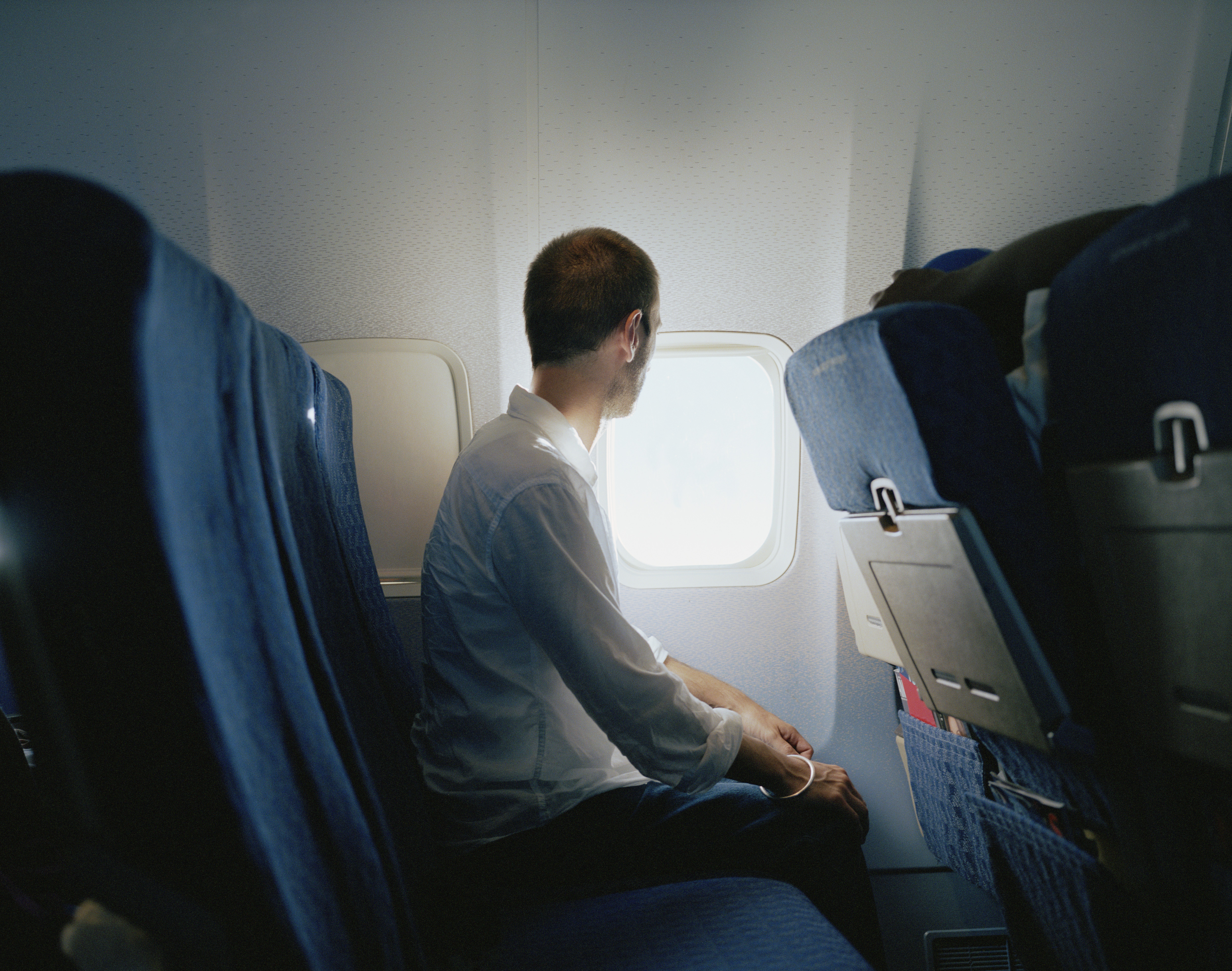 The person sitting in the window seat gets a view and can control the shade (stock image)