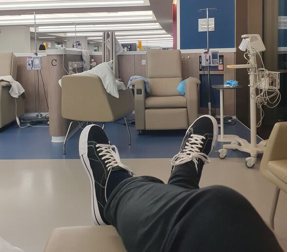 A man has his feet up in a chemotherapy ward