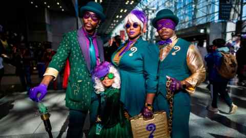 Attendees dressed as the Riddler pose during New York Comic Con 2022