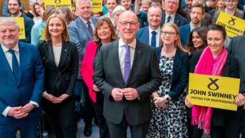 John Swinney with SNP supporters and fellow MSPs after a press conference at the Grassmarket Community Project in Edinburgh on Thursday